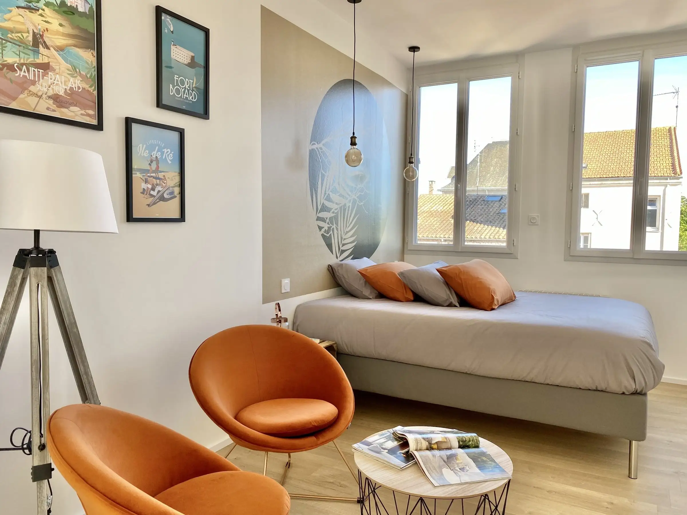 Studio Bleu Soleil avec fauteuils orange, lit 160 et affiches de la côte